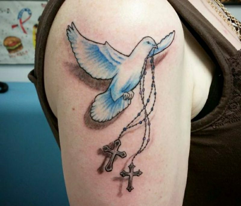 Kors tatuering med duvor på axeln