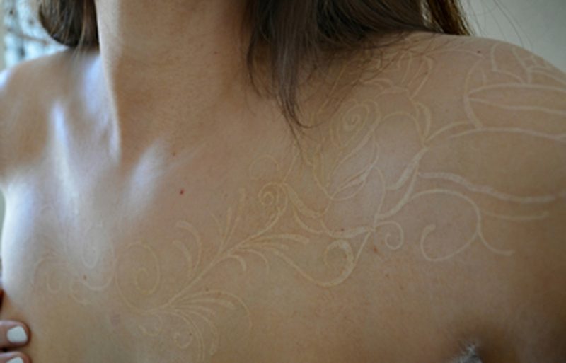 Tatuering vita blommor kvinna bröst axel