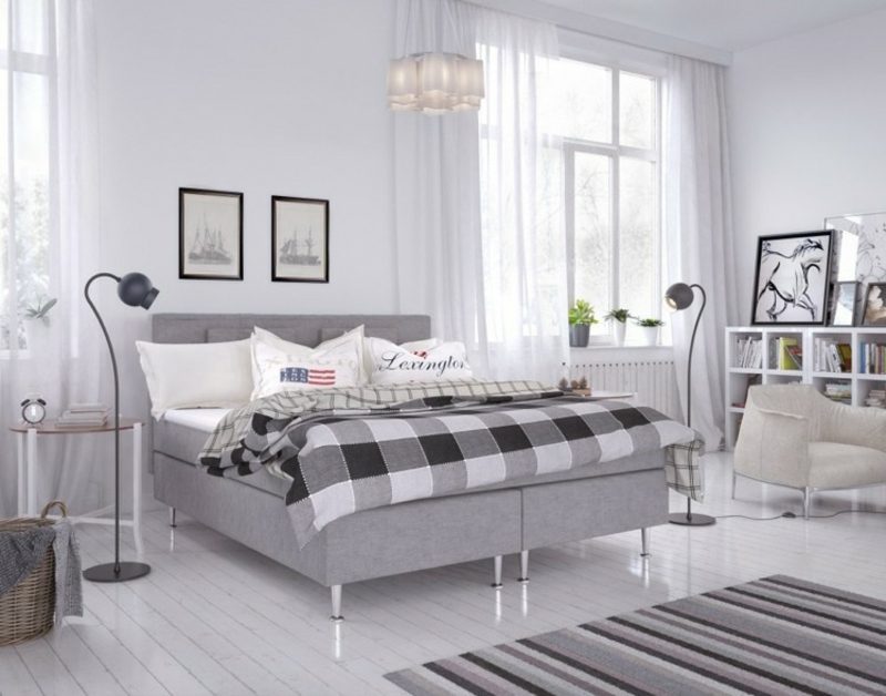 밝은 회색 패브릭 장식품이있는 박스 스프링 침대. 스칸디나비아 스타일